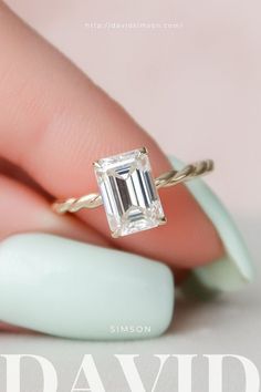 a woman's hand holding a ring with an emerald stone in it and the words david