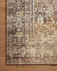 an area rug with various colors and patterns on the wood floor in front of a wooden wall