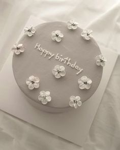 a birthday cake with white flowers on it