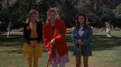 three women are standing in the grass with their canes