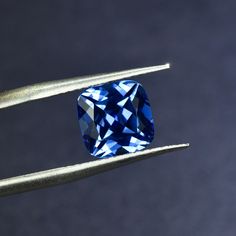 a blue diamond sitting on top of a piece of metal