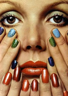 a woman's face with multicolored nails and manies on her hands