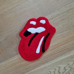 a towel shaped like the rolling stones on top of a wooden floor with its tongue sticking out