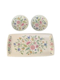 a set of three plates and two bowls with floral designs on the rims,