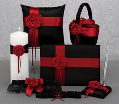 black and red wedding decor with roses on the pillow, candle, napkins, and candlesticks