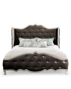 an upholstered bed is shown with pillows on the headboard and foot board