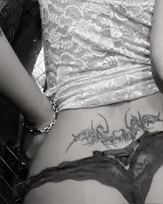 a woman with tattoos on her lower back