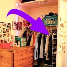 a closet with clothes hanging on the wall and a purple arrow pointing up at it