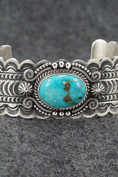 This stunning Kingman turquoise and sterling silver bracelet featuring a scalloped edge cuff was made by Navajo silversmith Michael Calladitto. The inside is signed M&R Calladitto and stamped Sterling.Size: 5 3/4" (will fit up to a 7 1/8" wrist)Gap: 1 3/8"Width: 1"Free shipping on all orders! We ship with USPS and always include tracking. All orders ship within a day of payment.Returns are accepted up to 30 days after you receive your order. Just send us a message. Our shop offers cash back or s Stamped Turquoise Bracelet, Turquoise Stamped Bracelet, Southwestern Etched Turquoise Jewelry, Southwestern Style Etched Turquoise Jewelry, Southwestern Turquoise Etched Jewelry, Etched Turquoise Sterling Silver Jewelry, Artisan Turquoise Engraved Bracelets, Artisan Turquoise Engraved Bracelet, Western Style Turquoise Stamped Bracelets