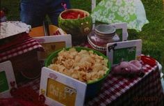 a table topped with lots of food on top of a grass covered field