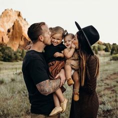 a man and woman are holding two small children