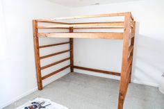 a wooden bunk bed sitting in a bedroom next to a white wall