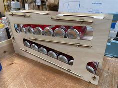 a wooden case with cans in it sitting on a table