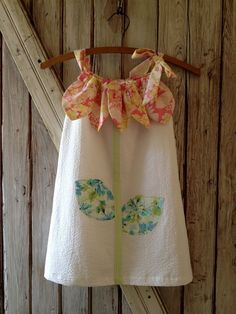 a white dress hanging on a wooden wall