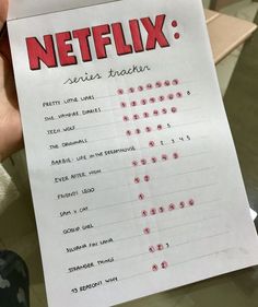 a person holding up a paper with the words netflix written on it