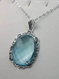 "Simulated Blue Aquamarine Necklace Bubble Design#P10 Custom Made Inspired by Victorian era designs, I now offer this lovely Antique reproduction in sterling silver. The flawless 22ct faceted simulated/Man-made blue Aquamarine is 24mm long (15/16th\") and 18mm in width (3/4th\"). The entire pendant is 1.5\" long and 7/8\" wide. The chain (if chosen) is between 16-18\" in length and is marked 925 as well. Notice the beautiful craftsmanship of the Victorian filigree setting. This pendant necklace Blue Oval Pendant Necklace For Wedding, Elegant Handmade Light Blue Necklace, Elegant Handmade Light Blue Necklaces, Elegant Light Blue Handmade Necklaces, Elegant Blue Filigree Necklace, Blue Aquamarine Pendant Necklace, Blue Aquamarine Necklaces For Jewelry Making, Blue Filigree Pendant Jewelry, Blue Filigree Necklace As Gift