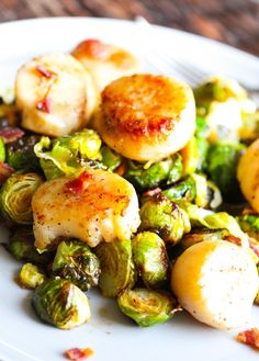 a white plate topped with brussel sprouts and scallops