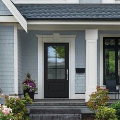 a gray house with white trim and black doors