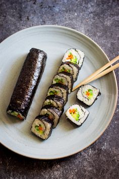 a plate with sushi and chopsticks on it