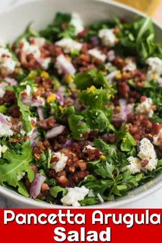 a salad with lettuce, feta cheese and other toppings in a white bowl