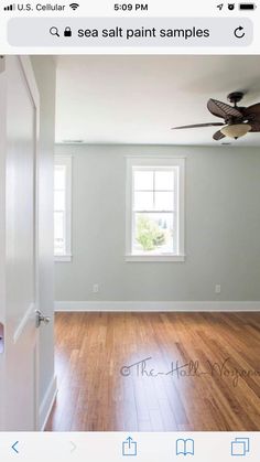 an empty room with wood floors and a ceiling fan in the middle of the room