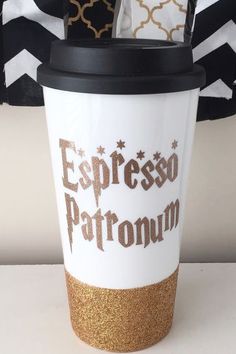 a coffee cup with the words espresso patronum written on it and gold glitters