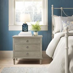 a bedroom with blue walls and white furniture