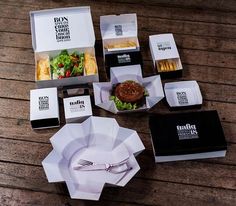 an open box with some food on top of it next to other boxes and utensils