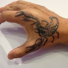 a hand with a scorpion tattoo on it