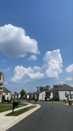 a street with houses and clouds in the sky