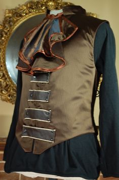 "This is a gentleman's waistcoat with a corseted back to give shape. Made in brown satin pinstripe. This listing is for the waistcoat only. The Jabot (round the neck) has it's own listing. Fully lined. metal and plastic boning. Fasteners are poppers. Measurements; Size Chest  Waist Nape to waist at the back  ( waistcoats are a few inches longer at the front than the back) *PLEASE NOTE*  You want the waistcoat to be about 2 \" too small so that it can act as a corset and give shaping at the back.  Waist measurements should be taken around the widest part of your tummy, not where you wear your trousers if that is lower, so don't use the measurement you use to buy trousers! Please fell free to ask for advice on fit. Pockets; no Collar; Yes" Steampunk Fitted Vest With Buttons, Steampunk Sleeveless Vest With Buttons, Fitted Steampunk Vest For Fall, Steampunk Formal Sleeveless Vest, Fitted Pinstripe Classic Vest, Classic Fitted Pinstripe Vest, Formal Steampunk Sleeveless Vest, Formal Sleeveless Steampunk Vest, Tailored Brown Vest With Buttons