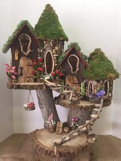 a tree stump with houses on it and flowers growing out of the trees around them