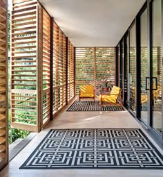 an outdoor area with wooden slats and black and white rug