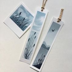 two bookmarks hanging from twine next to each other on a white table top