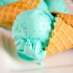 three scoops of ice cream on a white plate with blue icing in the middle