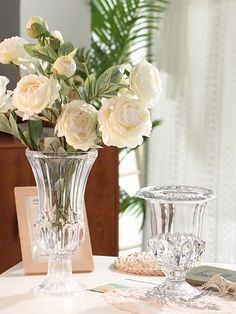 there is a vase with flowers in it on the table next to other glassware