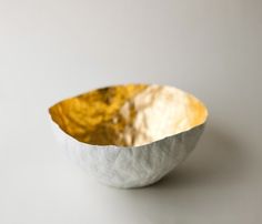 a white and gold bowl sitting on top of a table