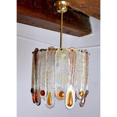 a glass chandelier hanging from a wooden ceiling