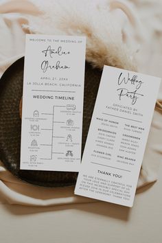 the wedding program was placed on top of a black plate with a white feather in it