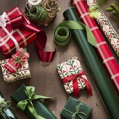 presents wrapped in green and red paper with bows on them sitting next to each other