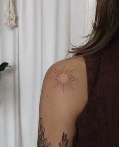 a woman with a sun tattoo on her arm