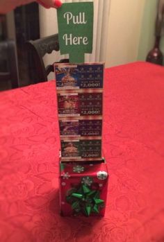 a stack of christmas cards sitting on top of a red tablecloth covered dining room table