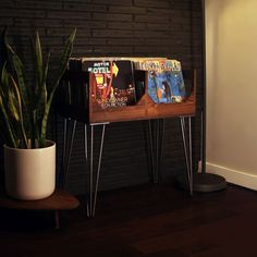 a wooden table with magazine racks and a potted plant