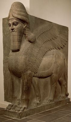 an ancient statue of a sphinx with wings and a headdress on it's back