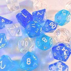 several blue and white dice laying on top of each other with numbers written on them