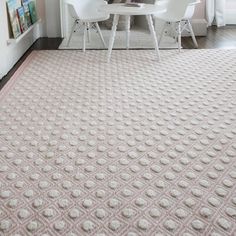 two white chairs sitting in front of a table on top of a carpeted floor