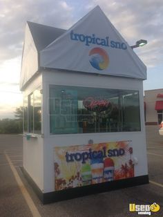 an ice cream kiosk in a parking lot with the words tropical sand written on it