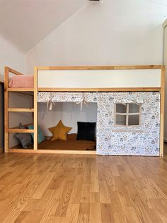 there is a bunk bed in the middle of this room with wood flooring and white walls