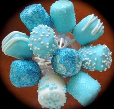 blue and white candies are arranged in a glass bowl on a table with black background