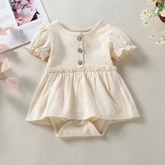 Size: 3-6m 6-12m 12-18m 18-24m Material: Cotton Care: Machine Wash Short Sleeve Bubble Romper With Ruffles For Playdate, Short Sleeve Ruffle Bubble Romper For Playdate, Cute Beige Bubble Romper With Ruffles, Cute Beige Ruffled Bubble Romper, Cream Cotton Bubble Romper With Short Sleeves, Cream Short Sleeve Bubble Romper For Summer, Cotton Puff Sleeve Playtime Dresses, Cotton Puff Sleeve Dresses For Playtime, Cute Cotton Bubble Romper With Buttons